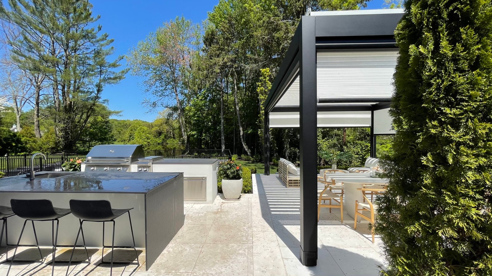Louvered pergola over an outdoor kitchen and dining area